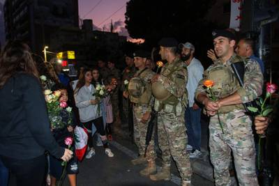 Lebanese protesters distribute roses to soldiers in Sidon (Saida). AFP