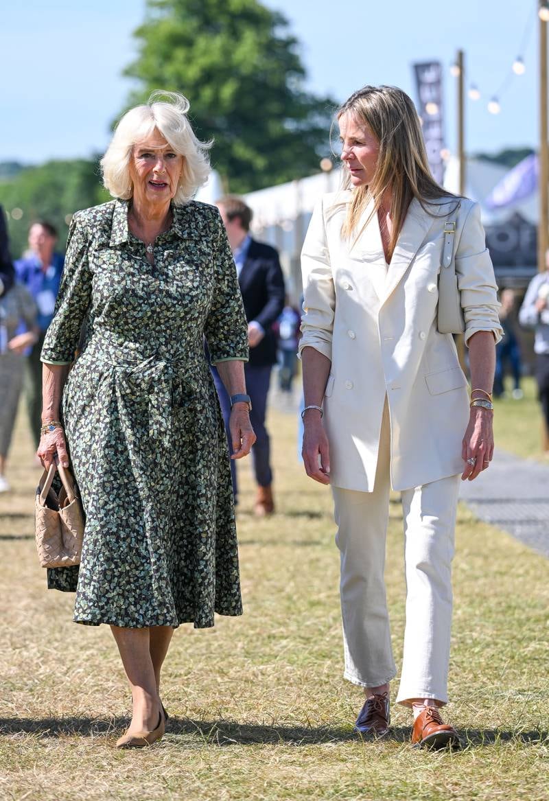 The duchess, wearing a green floral Fiona Clare dress, walks with Lady Rothermere at the Daily Mail Chalke Valley History Festival on June 20, 2022. Getty Images 