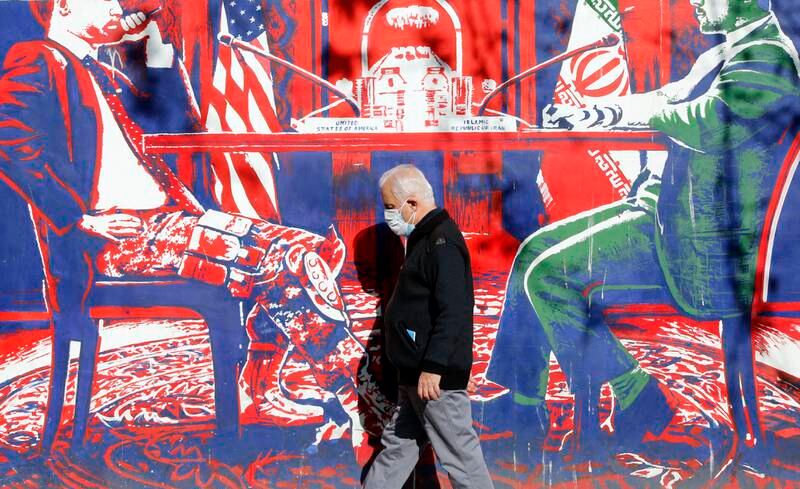 An Iranian man passes an anti-US mural on the wall of the former US embassy in Tehran. EPA