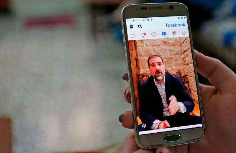A woman watches the Facebook video of Syrian businessman Rami Makhlouf on her mobile in Syria's capital Damascus, on May 11, 2020. Syria's top tycoon publicly airing his grievances has revealed a power struggle within the ruling family as it tries to cement its power after nine years of war, analysts say. After years of staying out of the limelight, business magnate Rami Makhlouf this month in two videos on Facebook laid bare his struggles with the regime headed by his first cousin President Bashar al-Assad, in what analysts say is a desperate last stand. / AFP / -
