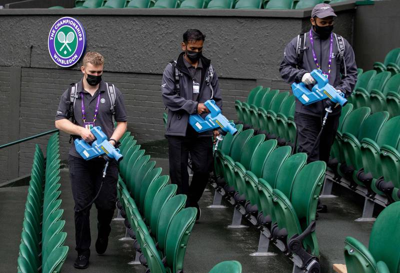 Staff spray the seats inside Centre Court with a disinfectant at The All England Tennis Club in Wimbledon, south-west London. AFP