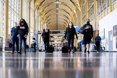 People wearing protective masks walk through Ronald Reagan National Airport in Arlington, Virgina, as air travel picks up in the US for this week's Memorial Day holiday. Global air passenger numbers are expected to be 52 per cent lower this year, according to Iata. Bloomberg
