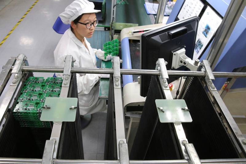 In this Aug. 27, 2019, photo, an employee works on the production line of a smart electricity meter manufacturing plant in Nantong in eastern China's Jiangsu province. Two surveys of Chinese manufacturing show demand is weak amid a mounting tariff war with Washington over trade and technology. (Chinatopix via AP)