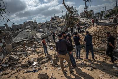 GAZA CITY, GAZA - May 13: Men walk on the rubble of a residential building in Gaza City, Gaza Strip, that was destroyed by an Israeli airstrike, on May 13, 2021 in Gaza City, Gaza. More than 65 people in Gaza and seven people in Israel have been killed in continued cross-boarder rocket exchanges as violence continues to escalate bringing fears of war. The escalation which erupted on Monday comes after weeks of rising Israeli-Palestinian tension in East Jerusalem, which peaked with violent clashes inside the holy site of Al-Aqsa Mosque. (Photo by Fatima Shbair/Getty Images)