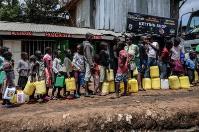 Children queue with their jerrycans to fill them with free water distributed by the Kenyan government at Kibera slum in Nairobi, Kenya.  AFP