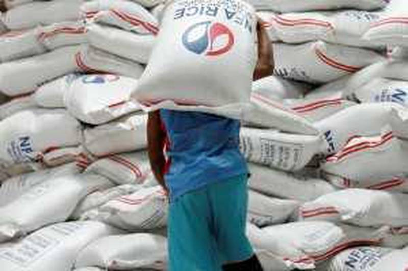 A worker carries a sack of imported rice inside a National Food Authority (NFA) warehouse in Quezon City, Metro Manila, May 13, 2008. Philippine farm output in the first quarter of the year rose 4.0 percent year-on-year and rice production was on course to reach a record 17.3 million tonnes in 2008, the government said on Tuesday. REUTERS/Romeo Ranoco (PHILIPPINES)