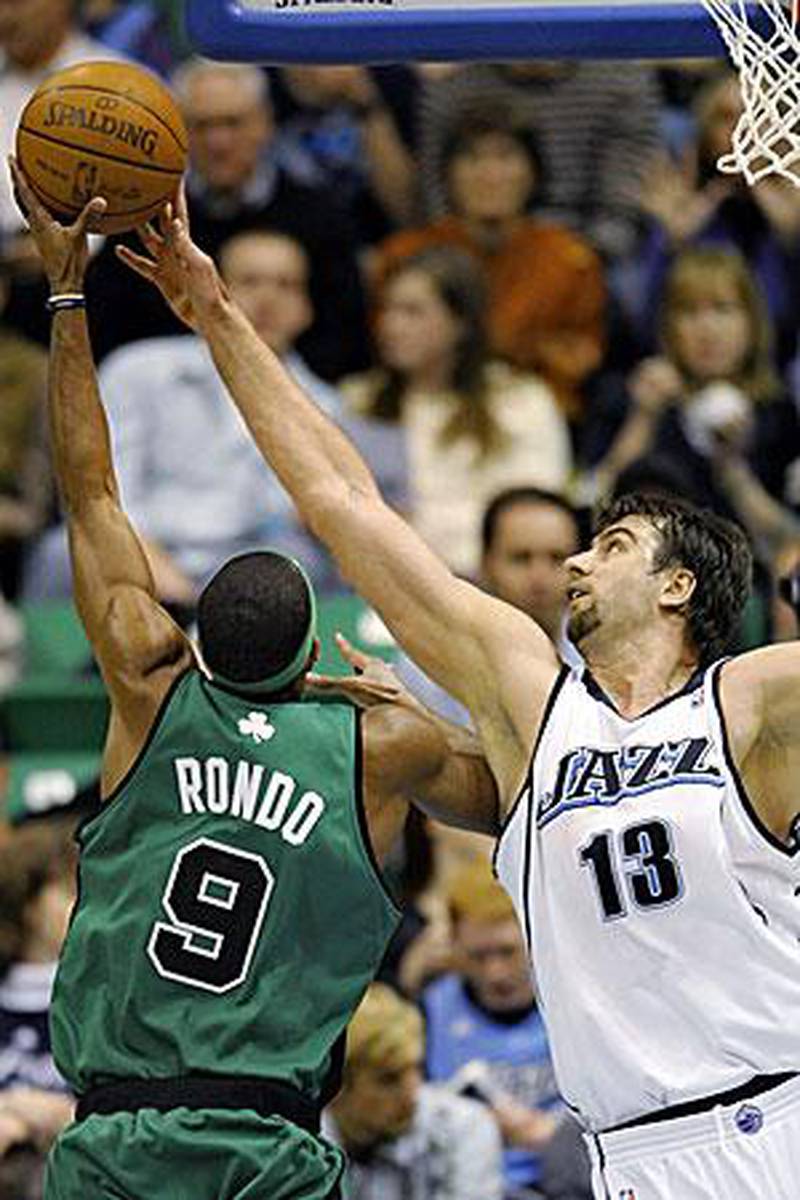 Boston's Rajon Rondo has his shot blocked by Mehmet Okur, the Utah Jazz centre.