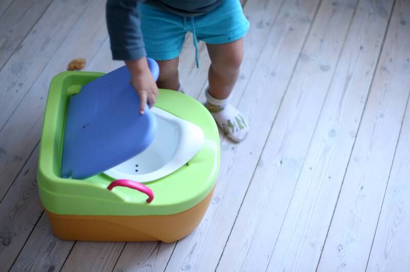 Some children benefit from a cushioned potty chair as well as doing an activity while on the toilet, like reading a storybook. Denis Closon / Shutterstock