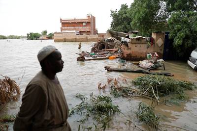 A man walks beside a flooded road in the town of Shaqilab, about 24 kilometres southwest of the capital, Khartoum. AP Photo