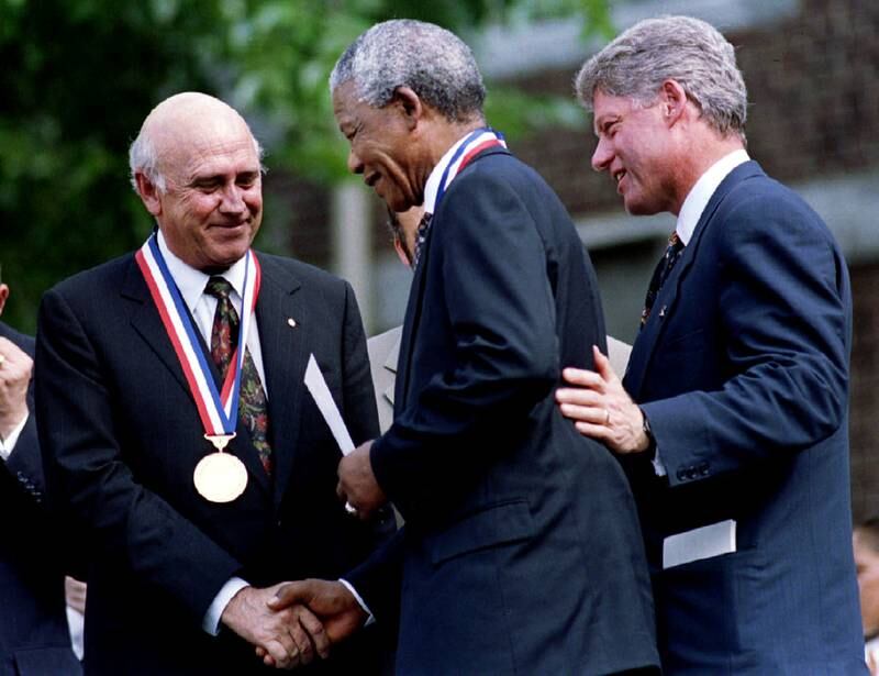 South African President F. W. DeKlerk (L) shakes hands with African National Congress leader Nelson Mandela (C) as US President Clinton looks on during Freedom Medal ceremonies in Philadelhpia July 4, 1993.  REUTERS/Win McNamee