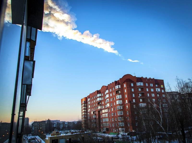 PRECISING NATURE OF FALLING OBJECT
A meteorite trail is seen above a residential apartment block in the Urals city of Chelyabinsk, on February 15, 2013. A heavy meteor shower rained down today on central Russia, sowing panic as the hurtling space debris smashed windows and injured dozens of stunned locals, officials said. AFP PHOTO / 74.RU/ OLEG KARGOPOLOV (Photo by OLEG KARGOPOLOV / 74.RU / AFP)