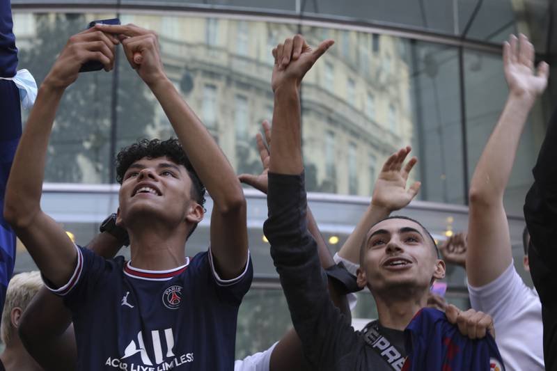 Supporters react as Lionel Messi appears at his hotel in Paris.