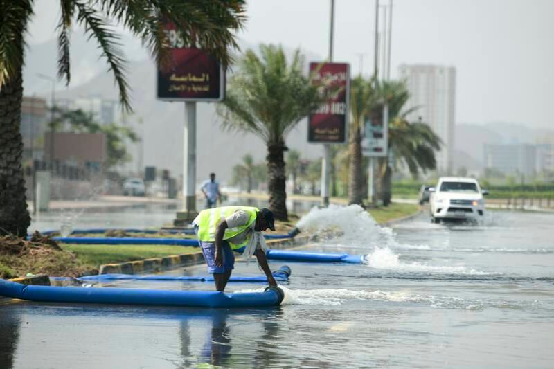 Municipality workers drain water from a flooded road in Fujairah. Khushnum Bhandari / The National