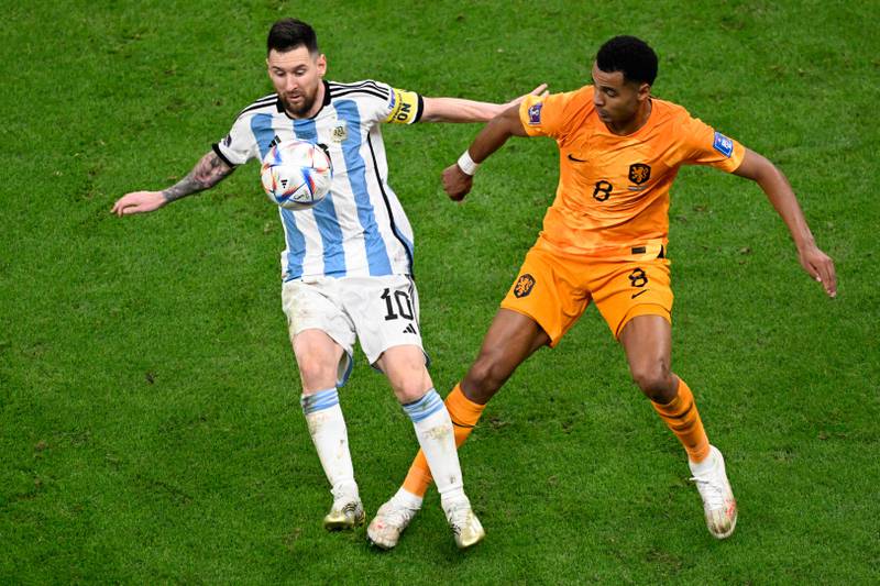 Argentina's Lionel Messi fights for the ball with Netherlands' forward Cody Gakpo during the Qatar 2022 World Cup quarter-final.  AFP