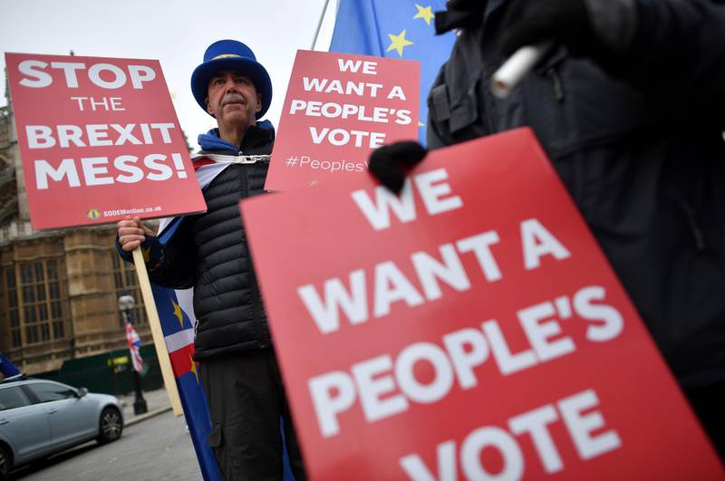 (FILES) In this file photo taken on November 22, 2018, pro-European Union (EU), anti-Brexit demonstrators hold placards calling for a "People's Vote" as they protest outside the Houses of Parliament in central London. Hopes for a second referendum on EU membership are rising in Britain amid heightened uncertainty over Brexit, but big hurdles remain -- from the timing to legal complexities on both sides of the Channel. / AFP / Ben STANSALL

