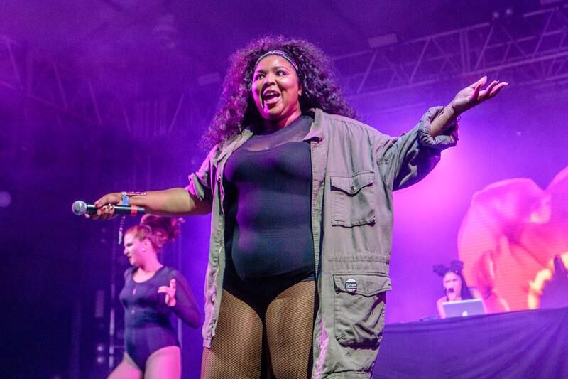 Lizzo wears a black bodysuit and baggy army-style jacket to perform at the Bonnaroo Music & Arts Festival on June 9, 2016, in Manchester, Tennessee. Photo: WireImage