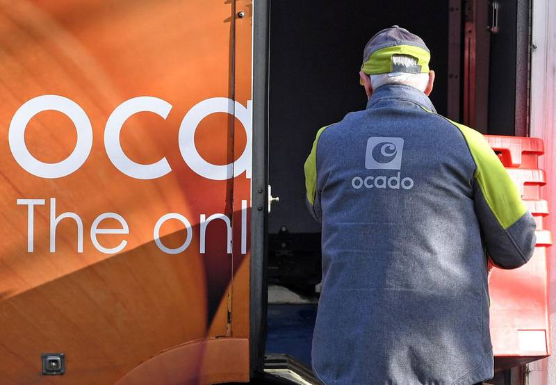 (FILES) In this file photo taken on February 10, 2019 a delivery driver returns empty crates to his Ocado delivery van after supplying a residential address near Liverpool in north west England. UK retailer Marks and Spencer on Wednesday announced a deal with online supermarket Ocado to deliver M&S food direct to homes, as customers increasingly move to internet shopping. / AFP / Paul ELLIS
