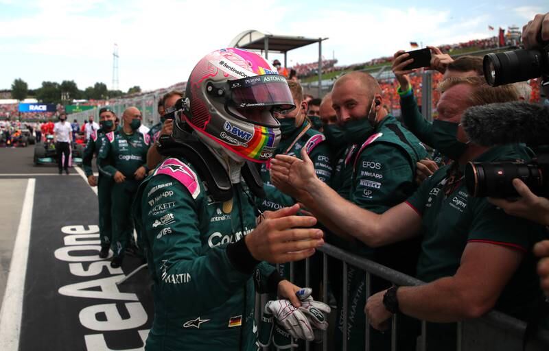 Aston Martin's Sebastian Vettel celebrates with team members after clinching second place at the Hungarian GP in 2021. EPA
