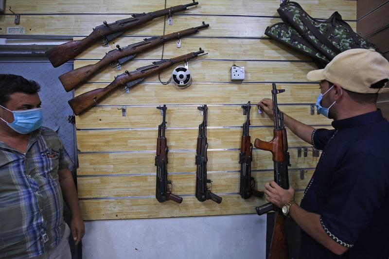 Employees display rifles for sale at a gun shop in the Iraqi capital Baghdad. AFP