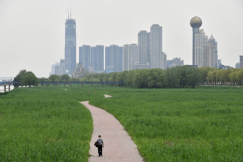 A man walks at a riverside park in Wuhan on March 26, 2020. Reuters