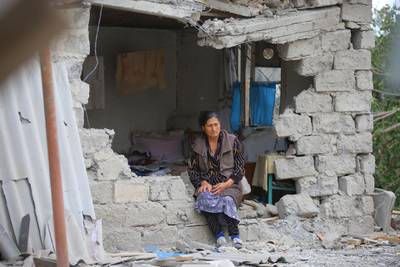 A woman sits in ruins of her house after shelling by Armenian's artillery during fighting over the separatist region of Nagorno-Karabakh, in Terter, Azerbaijan. AP