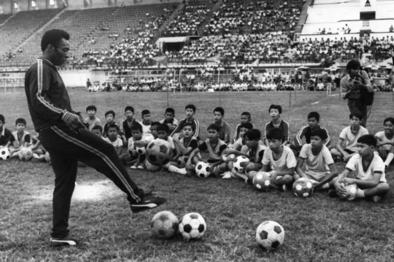During a training session with boys, as part of a trip to Thailand, in December 1974.  AFP