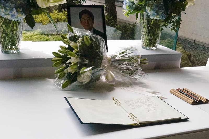 Mr Biden's bouquet of lilies sits opposite the book of condolence. AP