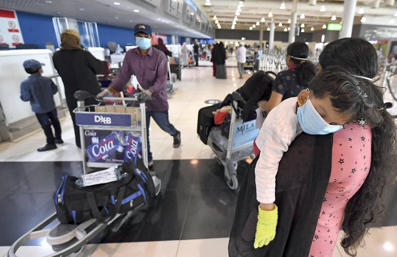 An Indian woman carries a sleeping child as she waits at the Dubai International Airport before leaving the Gulf Emirate on a flight back to her country, on May 7, 2020, amid the novel coronavirus pandemic crisis.  The first wave of a massive exercise to bring home hundreds of thousands of Indians stuck abroad was under way today, with two flights preparing to leave from the United Arab Emirates.
India banned all incoming international flights in late March as it imposed one of the world's strictest virus lockdowns, leaving vast numbers of workers and students stranded.

  


  
 / AFP / Karim SAHIB
