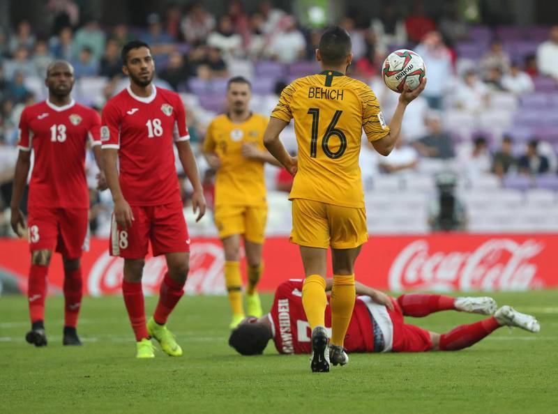 Australia's defender Aziz Behich holds the ball as Yousef Al Rawashdeh lies on the ground. AFP