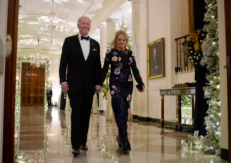 US President Joe Biden and first lady Jill Biden, wearing a  navy floral dress, arrive at the reception. EPA