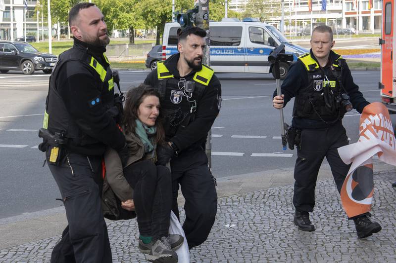 Police officers remove a climate activist in Berlin. AP