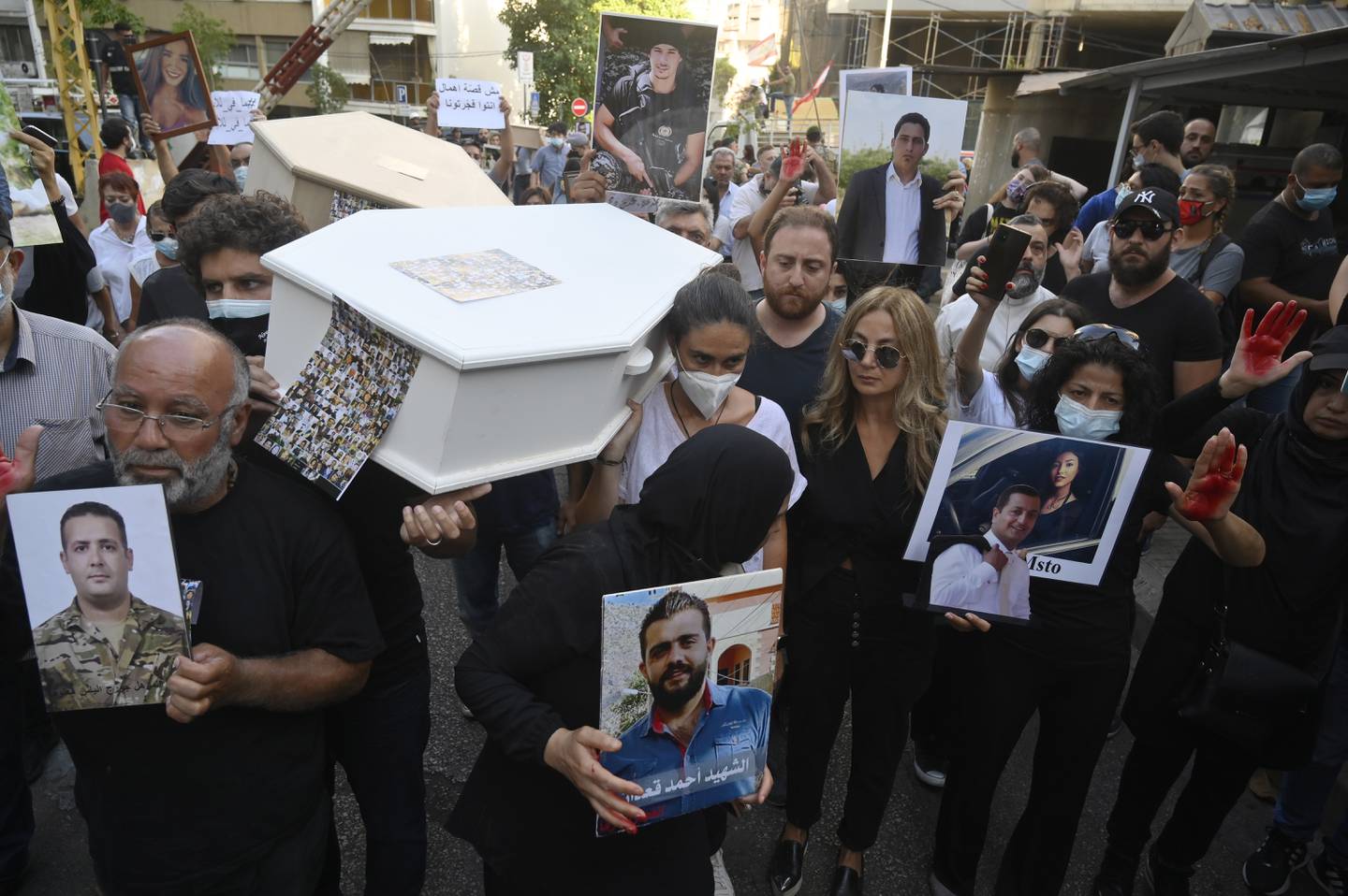 Families and relatives of victims of the 04 August Beirut port explosion carry empty coffins and portraits of the deceased relatives during a protest outside the house of Lebanese Interior Minister Mohammed Fahmi, in Beirut, Lebanon, July 13. EPA