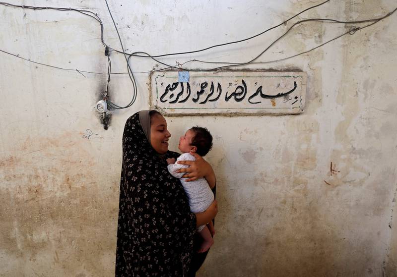 Lamis Kuhail, 12, plays with her 2-month-old brother, Ahmed, at their family home in the Sheikh Shaban cemetery, Gaza city. All photos: Reuters 