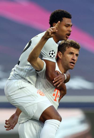 epa08604099 Thomas Mueller (R) of Bayern Munich celebrates with teammate Serge Gnabry after scoring the 1-0 lead during the UEFA Champions League quarter final match between Barcelona and Bayern Munich in Lisbon, Portugal, 14 August 2020.  EPA/Rafael Marchante / POOL
