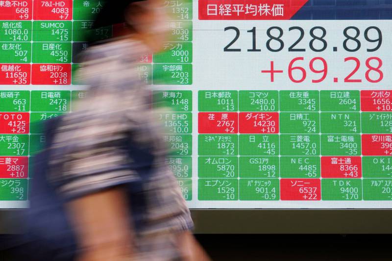 A person walks past an electronic stock board showing Japan's Nikkei 225 index at a securities firm in Tokyo Friday, Sept. 13, 2019. Stocks were broadly higher in Asia on Friday after gains overnight on Wall Street. Investors have stepped up buying on hopes for an easing of tensions in the costly trade war between the U.S. (AP Photo/Eugene Hoshiko)