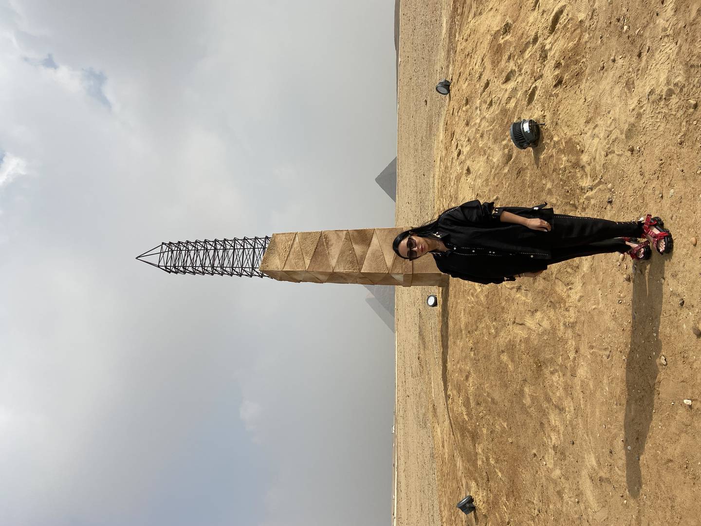 Zeinab Alhashemi se tient devant sa structure enveloppée de peau de chameau.  Elle espère que cela fait allusion aux motifs et aux teintes des sables qui l'entourent.  Nada El Sawy / Le National