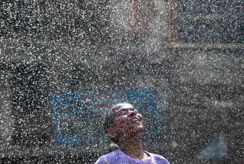 A boy plays with water during in Kathmandu, Nepal. EPA