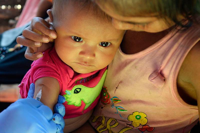 A health worker injects the child of a Rohingya refugee with a vaccine in Kutupalong refugee camp. AFP