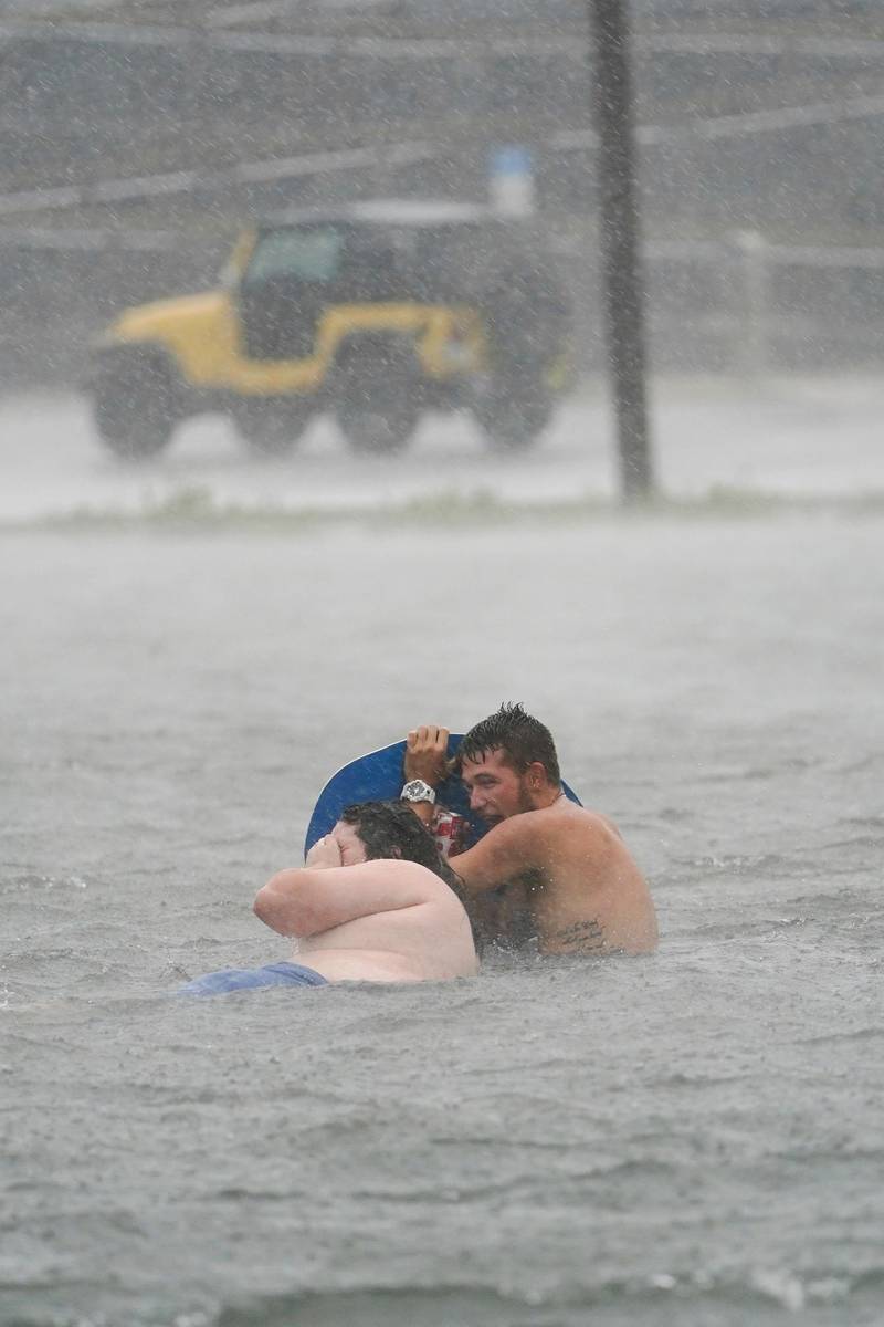 People play in a flooded parking lot at Navarre Beach, in Pensacola Beach, Florida. AP Photo