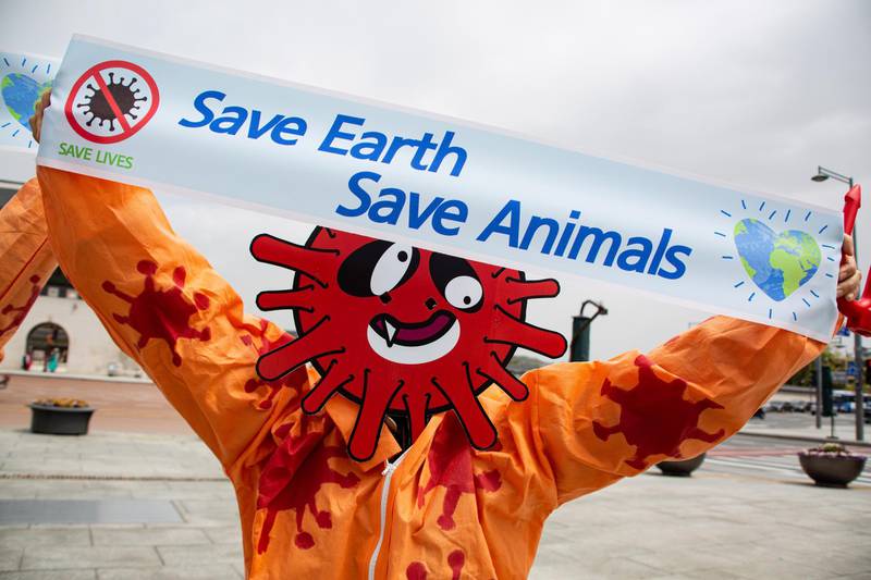 epa08376487 A member of the Environmental Health Citizens' Association of Korea, wearing a mask representing the SARS-CoV-2 coronavirus, holds a banner during the 50th anniversary of Earth Day, at Gwanghwamun Square in Seoul, South Korea, 22 April 2020. Earth Day is celebrated every year on 22 April to raise awareness on environmental protection.  EPA/JEON HEON-KYUN