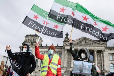 Syrians hold their national flag in front of Berlin's  Reichstag building to draw attention to the 150,000 people missing in Syria. from 15 March 2011. EPA