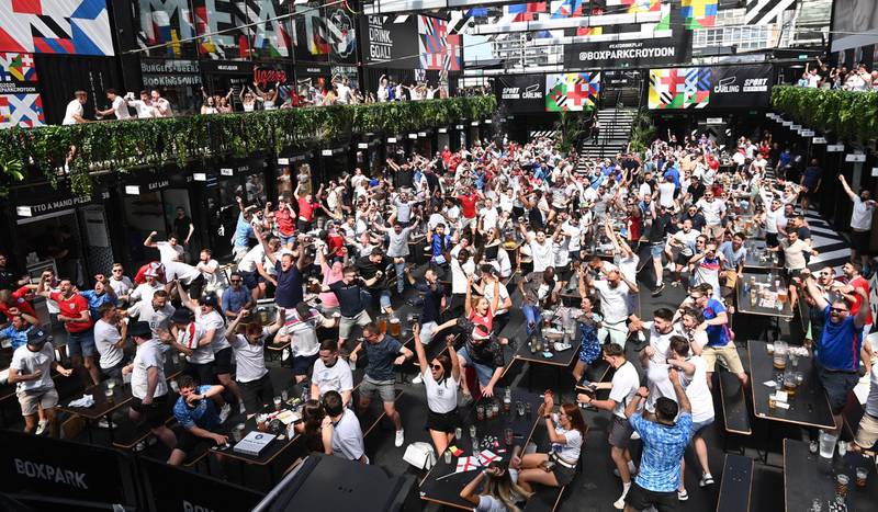 England supporters celebrate as they watch a public viewing of the UEFA EURO 2020 match between England and Croatia, in Boxpark, Croydon. EPA