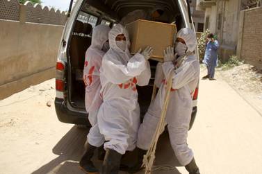 Workers prepare the burial of a victim who died of coronavirus in Hyderabad, Pakistan. EPA