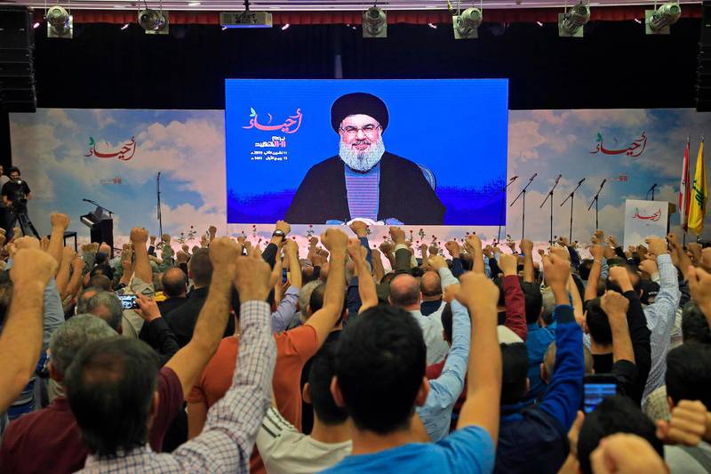 Lebanese Hezbollah Leader Hassan Nasrallah is cheared by his suppoters as he speaks through a giant screen on the occasion of the group's "martyr's day" in the capital Beirut's southern suburb, on Novemebr 11, 2019. / AFP / -
