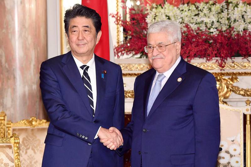 Mr Abe, left, shakes hands with Palestinian President Mahmoud Abbas during a meeting at the State Guesthouse.  AP