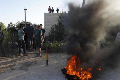Israeli settlers burn tyres to protest against the evacuation. Menahem Kahana / AFP