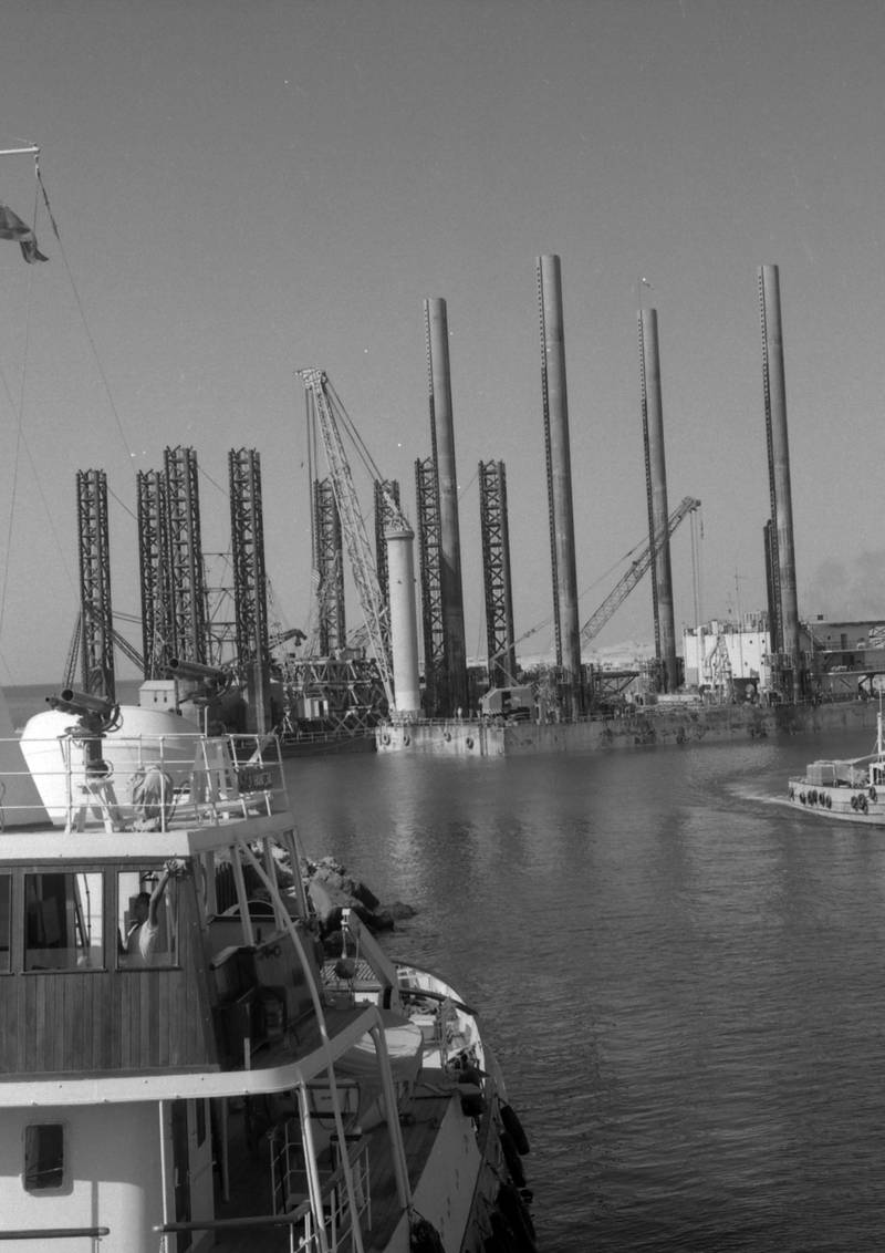 The harbour at Das Island from the deck of the ADMA tug Arzanah showing the work barge ADMA Constructor and the drilling barge  Offshore 55 at berth. 1962 *** Local Caption *** *eds note* Mandatory Credit - Courtesy BP Archive