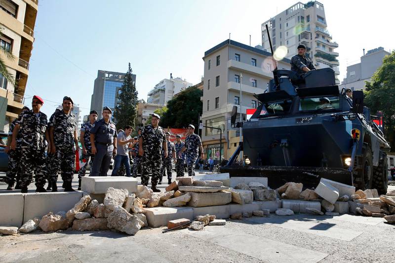 Police remove stones set up by anti-government protesters to block a main road in Beirut, Lebanon, Wednesday, Oct. 30, 2019. There was so significant resistance from protesters as army units with bulldozers took down barriers and tents set up in the middle of highways and major intersections Wednesday. (AP Photo/Bilal Hussein)