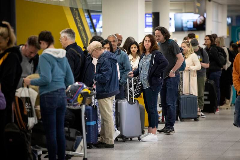 Travellers queue to check in for their flights at Gatwick. EPA