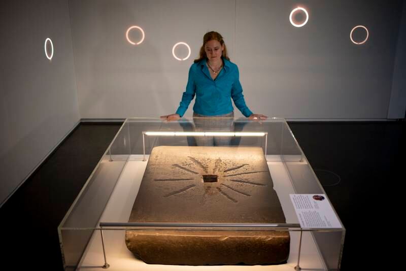 A British Museum employee poses with the Shabaka Stone at the museum. EPA